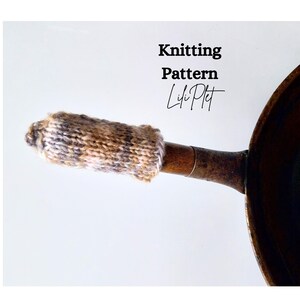 May include: A knitted pot handle cover in shades of brown, tan, and gray, partially covering a wooden handle. The image includes the text "Knitting Pattern" and the name "Lili Plet". The cover is designed to protect hands from heat.