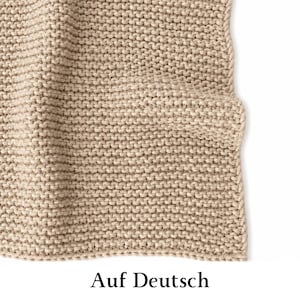 May include: A beige knitted blanket featuring a consistent garter stitch pattern with a visible vertical edge. The fabric has a textured, looped appearance throughout, showcasing a neutral tan color and a uniform, dense weave structure.