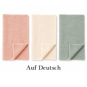 Puede incluir: Tres mantas rectangulares de punto dispuestas una al lado de la otra. Las mantas son de color rosa suave, crema y verde salvia. Cada manta presenta una textura uniforme de punto bobo y un detalle de esquina doblada. Texto "Auf Deutsch".