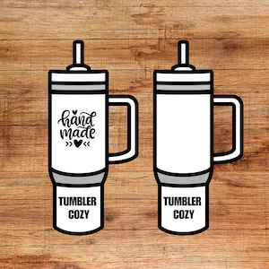 Puede incluir: Dos vasos blancos con tapas y asas negras. El vaso de la izquierda tiene el texto "hand made" con un diseño de corazón. Ambos vasos tienen el texto "Tumbler Cozy" impreso en la parte inferior.