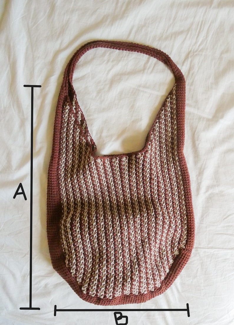 May include: A handmade crochet shoulder bag in a vertical striped pattern of burgundy and cream. The bag has a rounded bottom and a single strap. The bag's dimensions are approximately 15 inches wide and 20 inches long.