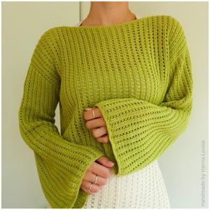 May include: A green crocheted sweater with bell sleeves. The sweater has a loose fit and a wide neckline.