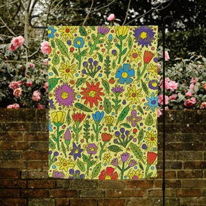 Può includere: Una bandiera da giardino con un vivace motivo floreale. Il design presenta fiori colorati in rosso, giallo, viola e blu su uno sfondo giallo chiaro. La bandiera è appesa a un supporto in metallo nero, ideale per l'arredamento esterno.