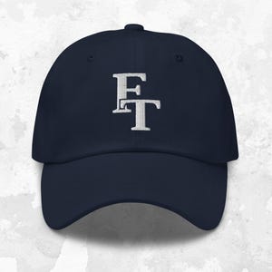 May include: A navy blue baseball cap with a white embroidered "ET" logo.