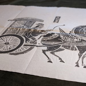 Pode incluir: Uma folha retangular de papel off-white com uma impressão em tinta preta de uma carruagem puxada por um cavalo. A ilustração mostra um cavalo puxando uma carroça coberta com uma pessoa dentro, incluindo um pequeno selo retangular com texto.