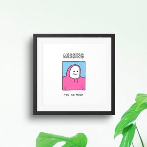 Könnte beinhalten: Ein gerahmter Kunstdruck mit schwarzem Rahmen. Das Kunstwerk zeigt eine Cartoonfigur in einem rosa Kapuzenpullover vor blauem Hintergrund mit den Worten "MISSING" oben und "YOU SO MUCH" unten.