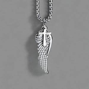 May include: A silver pendant necklace with a cross and angel wing design. The pendant is suspended from a box link chain. The wing has detailed feathering, and the cross is positioned above the wing.