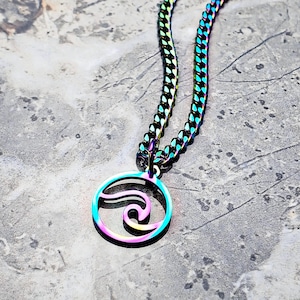 May include: A rainbow iridescent chain necklace with a circular pendant featuring a wave design.
