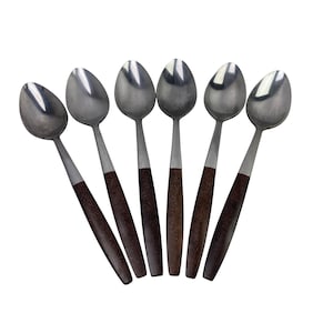 May include: Six stainless steel spoons with dark brown wooden handles. The spoons are arranged in a fan shape against a white background. The spoons have a classic, elegant design.
