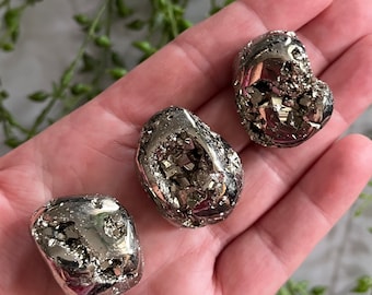May include: Three silver-colored pyrite stones with a rough, textured surface. The stones are irregularly shaped and have a metallic sheen.