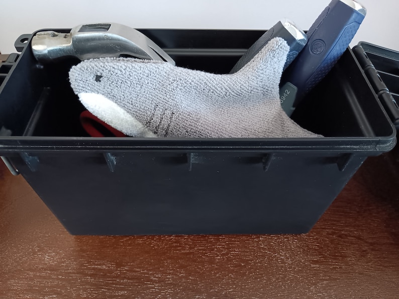 Shark glasses case peeking out of a tool box