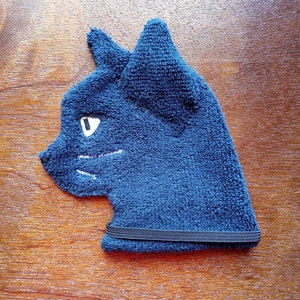 May include: A blue cat-shaped eye mask with a black elastic band. The mask is made of a soft, plush material.