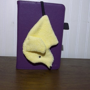 A Smudge Dog with its 1/4 inch braided elastic looped through a case of an e-reader. Handy for cleaning screen of reader as well as eye glasses.