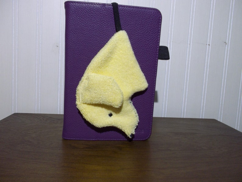 A Smudge Dog with its 1/4 inch braided elastic looped through a case of an e-reader. Handy for cleaning screen of reader as well as eye glasses.