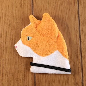 May include: Orange and white cat-shaped microfiber cleaning cloth with a black elastic band.
