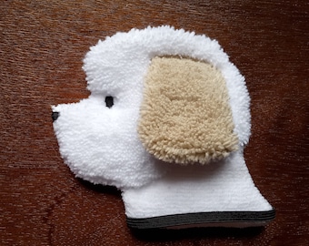 May include: White and beige plush dog-shaped hand puppet with black eyes and a black trim around the bottom edge.