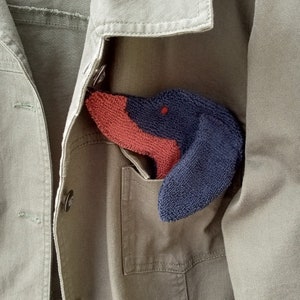 Smudge Dog shown peeking out of a jean jacket chest pocket. Cute way to personalize and outfit with a necessary accessory.