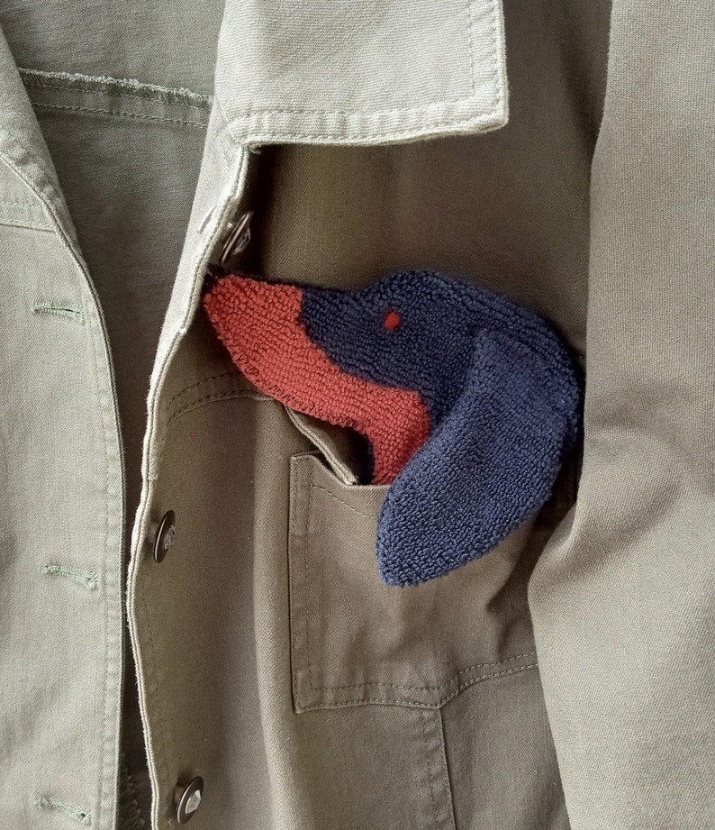 Smudge Dog shown peeking out of a jean jacket chest pocket. Cute way to personalize and outfit with a necessary accessory.