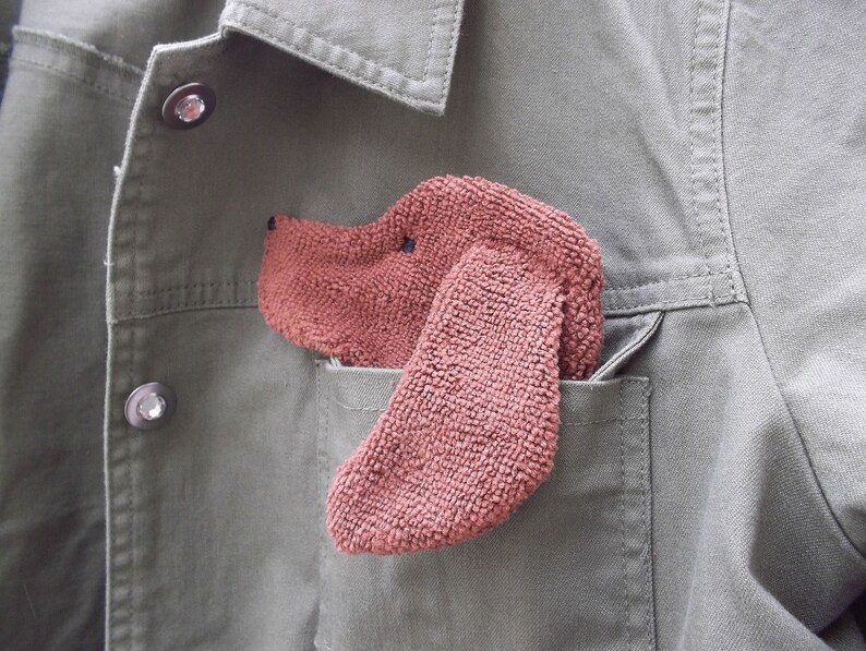 Smudge Dog shown peeking out of a jean jacket chest pocket. Cute way to personalize and outfit with a necessary accessory.
