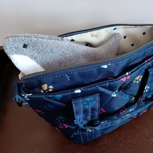 Shark shaped glasses case peeking out of handbag