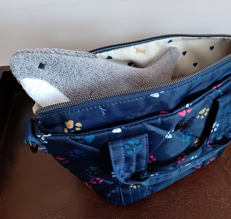 Shark shaped glasses case peeking out of handbag