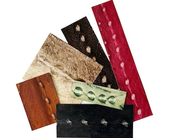 May include: Assortment of six leather samples in various colours and patterns, including brown, black, red, and green. The samples are arranged in a fan shape.