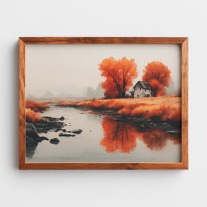 Puede incluir: Una pintura de paisaje enmarcada representa una serena escena otoñal. Vibrantes árboles naranjas se alzan junto a un edificio desgastado, reflejados en un río tranquilo. La obra de arte está encerrada en un cálido marco de madera, realzando el encanto rústico.