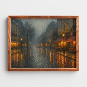 May include: A framed painting of a rainy street scene with cobblestone paving. The artwork shows buildings with lit windows and awnings, street lamps, and reflections of lights on the wet street. The frame is made of wood.