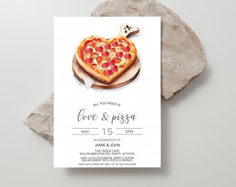 May include: A white invitation card with a watercolor illustration of a heart-shaped pizza on a wooden cutting board. The text on the card reads "All you need is love & pizza" and includes details for an engagement party for Jamie & John at The Pizza Cafe.
