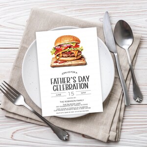 May include: A white Father's Day celebration invitation with a cartoon illustration of a hamburger. The invitation includes the date, time, and location of the event. It also includes the text "Join us for a Father's Day Celebration" and "Hosted by The Robinson Family".
