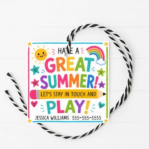 Pode incluir: Uma etiqueta de presente quadrada com um design colorido de verão. A etiqueta apresenta o texto "HAVE A GREAT SUMMER! LET'S STAY IN TOUCH AND PLAY!" juntamente com um sol, um arco-íris, estrelas e corações. Está presa a um cordão preto e branco.