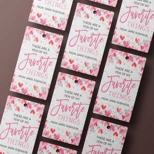 K&ouml;nnte beinhalten: Sechs rosa und wei&szlig;e Geschenkanh&auml;nger mit einem Aquarell-Herz-Muster. Die Anh&auml;nger haben den Text "Das sind ein paar meiner Lieblingssachen" und "Von: Jamie Robinson".