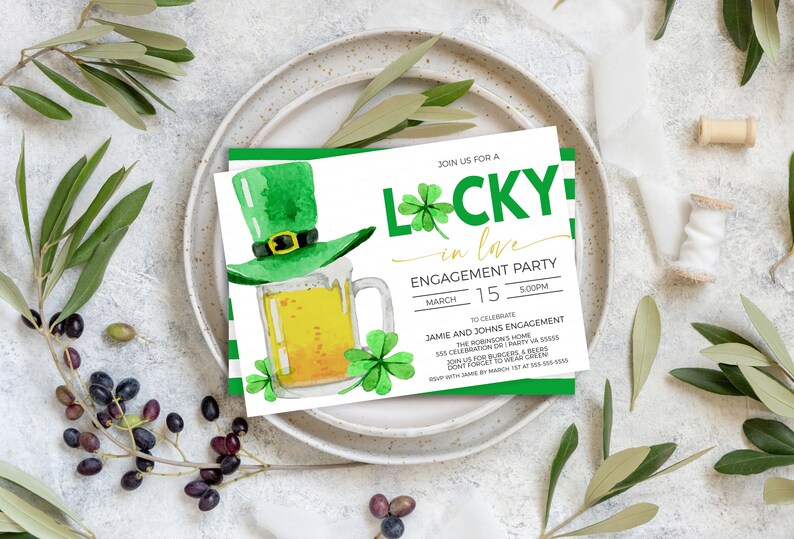 May include: An engagement party invitation with a St. Patrick's Day theme. The invitation features a green leprechaun hat, a mug of beer, and shamrocks. The text reads "Lucky in Love" and includes event details.