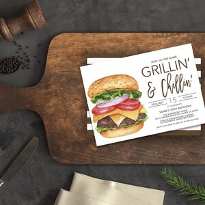 May include: A white invitation card featuring a watercolour illustration of a hamburger. The text on the card reads "Join us for some Grillin' & Chillin'" and includes details for Jamie's 35th birthday party.