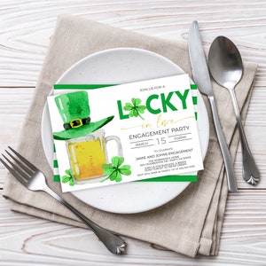 May include: An engagement party invitation with a St. Patrick's Day theme. The invitation features a green leprechaun hat, a mug of beer, and shamrocks. The text reads "Lucky in Love" and includes event details.