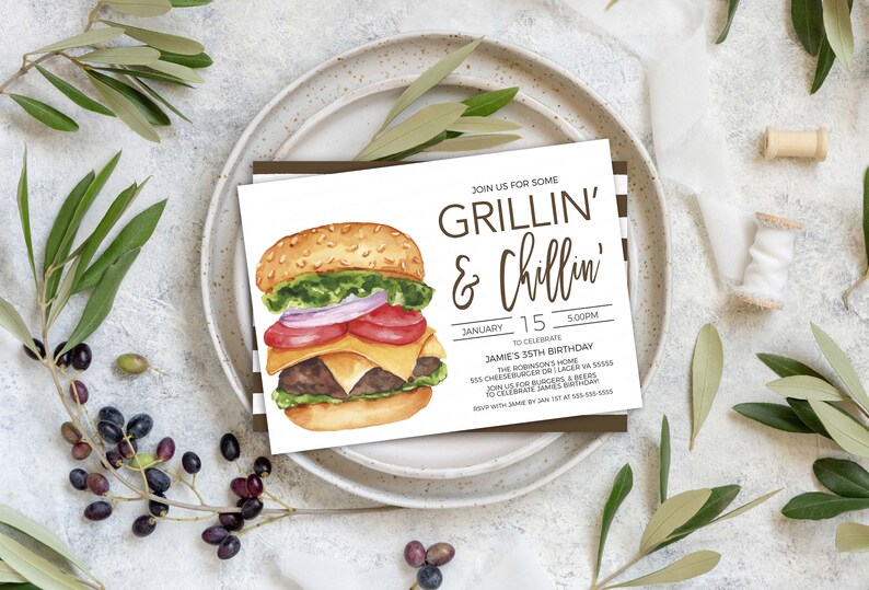 May include: A white invitation card with brown text that reads "Join us for some Grillin' & Chillin'" and details for a birthday party. The card features a watercolour illustration of a hamburger with lettuce, tomato, onion, cheese, and a beef patty.