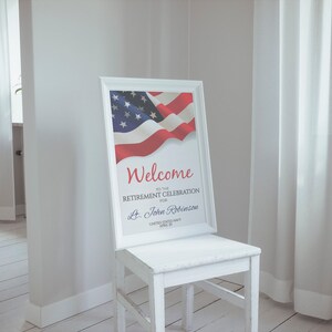 May include: A white framed sign with an American flag and the text "Welcome to the Retirement Celebration for Lt. John Robinson, United States Navy, April 20".