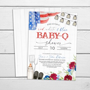 May include: Red, white, and blue baby shower invitation with a watercolor American flag, string lights, and floral accents. The invitation reads "Join us for a red, white & blue baby-q shower" with the date and time of the event. The invitation also includes the names of the parents-to-be, Jamie & John Robinson, and the address and RSVP information.