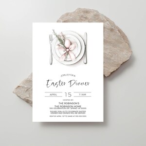 May include: A white invitation card with a hand-drawn illustration of a plate with a pink Easter egg and a sprig of flowers. The text on the card reads "Join us for an Easter Dinner, April 15, 11 AM, Hosted by: The Robinson's, The Robinson Home, 555 Celebration Dr | Spring VA 55555, Please join us to celebrate Easter dinner and drinks will be served, RSVP by April 1st to Jamie at 555-555-5555".