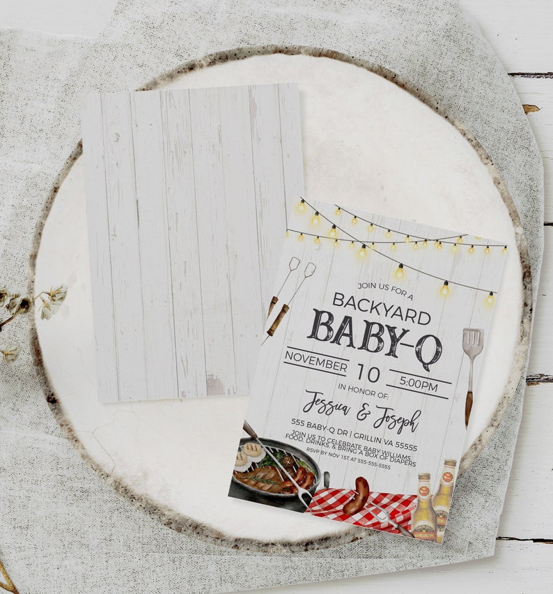 May include: A white woodgrain background with a white invitation card. The invitation card has a rustic design with string lights, a spatula, and a grill. The text on the card reads "Join us for a Backyard Baby-Q, November 10, 5:00 PM, In honor of Jessua & Joseph, 555 Baby-Q Dr. Grillin VA 55555, Join us to celebrate a baby shower, Food, drinks, bring a pack of diapers, RSVP by Nov 1st at 555-555-5555".