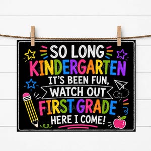 Könnte beinhalten: Ein schwarzes Schild im Tafelstil mit dem Text "SO LONG KINDERGARTEN, IT'S BEEN FUN, WATCH OUT FIRST GRADE, HERE I COME!" in farbiger Kreideschrift. Das Schild ist mit Sternen, einem Bleistift, einem Apfel und einem Papierflieger verziert. Das Schild hängt an einer Wäscheleine mit Holzklammern.