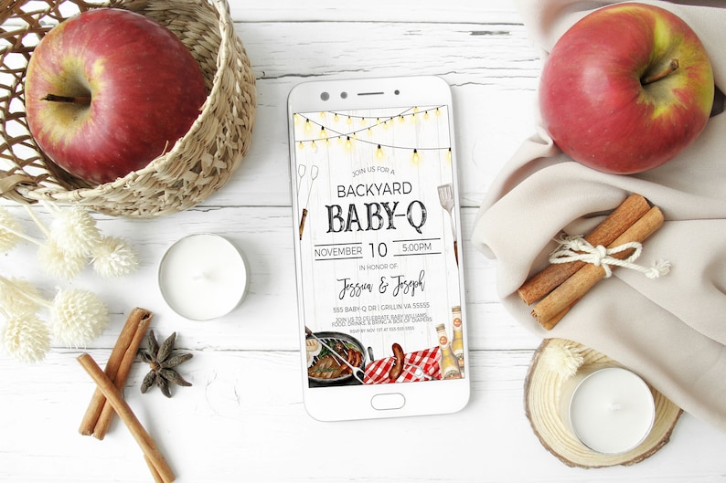 May include: A smartphone displaying a digital invitation for a backyard baby-Q. The invitation features a rustic wood background with string lights, a grill, and a red and white checkered picnic blanket. The text reads "Join us for a Backyard Baby-Q, November 10, 5:00PM, in honor of Jessun & Josoph, 555 Baby Dr,  Crillin, VA 55555".