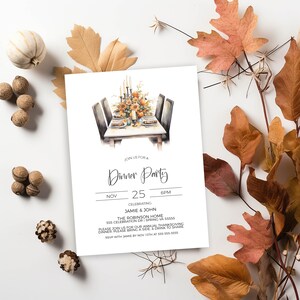 Könnte beinhalten: Eine weiße Einladungskarte mit dem Text "Dinner Party" in eleganter Schrift. Die Karte zeigt eine Aquarellillustration einer Thanksgiving-Tischdekoration. Getrocknete Blätter und dekorative Elemente umgeben die Karte und schaffen ein Herbstthema.