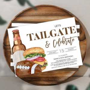 May include: A white invitation card with brown text that reads "Let's Tailgate & Celebrate". The card features a watercolor illustration of a hamburger, a bottle of beer, and a football. The text on the card includes the date "January 15" and the time "5:00PM". The invitation is for Jamie's 35th birthday party.