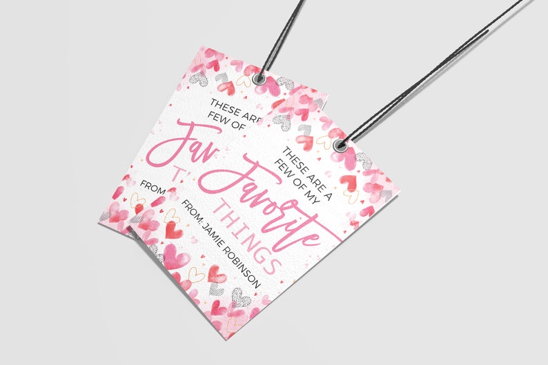 K&ouml;nnte beinhalten: Ein wei&szlig;es Geschenkanh&auml;nger mit einem rosa Aquarell-Herz-Muster. Der Anh&auml;nger hat den Text "Das sind ein paar meiner Lieblingsdinge" und "Von: Jamie Robinson".