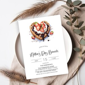 K&ouml;nnte beinhalten: Eine wei&szlig;e Einladungskarte mit einer Aquarell-Illustration einer herzf&ouml;rmigen Waffel, die mit Schlagsahne, Erdbeeren und Schokoladensauce bedeckt ist. Der Text auf der Karte lautet "Join us for a Mother's Day Brunch, May 15, 11 AM, Hosted by: The Robinson's, The Robinson Home, 555 Celebration Dr | Spring VA 55555, Please join us to celebrate Mother's Day with a brunch and drinks, RSVP by May 1st to Jamie at 555-555-5555."