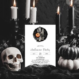 May include: A Halloween party invitation with a skull, pumpkins, and lit candles. The invitation features a plate setting with a pumpkin and cutlery. The text reads "Halloween Party" with the date and time.