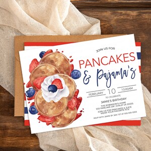 May include: A white invitation card with blue and red stripes on the bottom. The card has a watercolor illustration of pancakes with whipped cream, strawberries, and blueberries. The text on the card reads "Join us for Pancakes & Pajama's!"  "February 10, 10:00 AM" "To Celebrate Jamie's Birthday" "The Robinson's Home 555 Pancake Dr. Syrup, VA 55555" "Join us for pancakes & juice" "Wear your favorite PJs" "RSVP with Jamie by Jan 1st at 555-555-5555"
