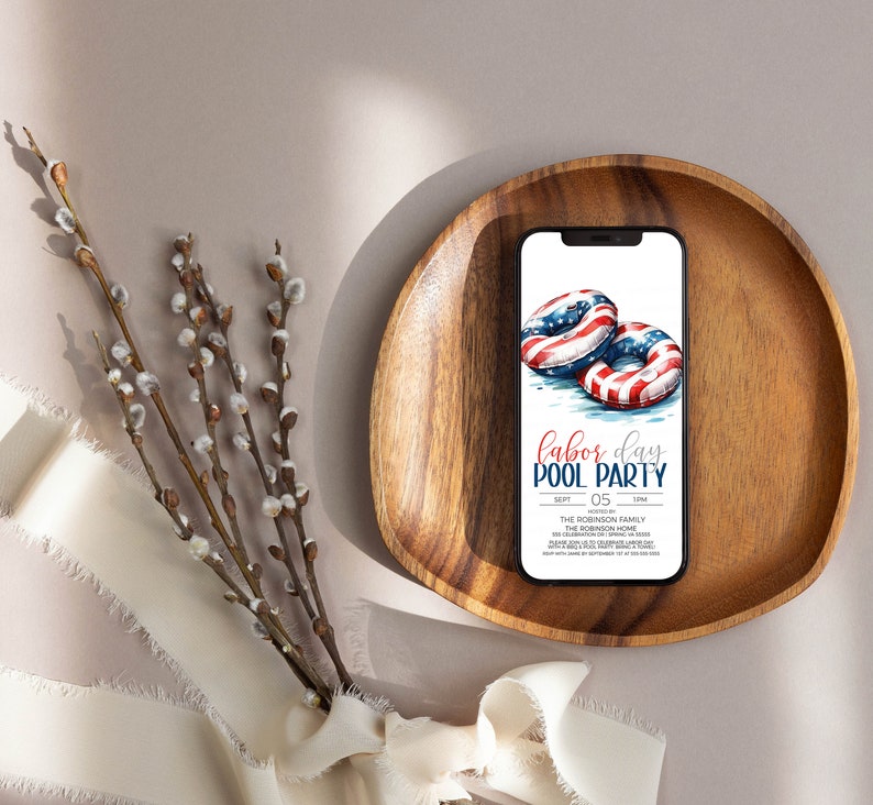 May include: A digital invitation for a Labor Day pool party. The invitation features a watercolor illustration of two red, white, and blue inflatable pool rings. The text on the invitation reads "Labor Day Pool Party" with the date "Sept 05" and the time "1 PM".
