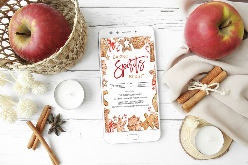 May include: A smartphone displaying a digital invitation for a "Baking Spirits Bright" Christmas cookie decorating party. The invitation features a watercolor illustration of gingerbread cookies, candy canes, and other holiday decorations. The party is hosted by the Robinson family on December 10th at 5:00 PM.